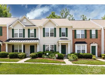 Charming townhouse with a well-manicured lawn, green door, shutters, and inviting curb appeal at 12328 Jessica Pl, Charlotte, NC 28269