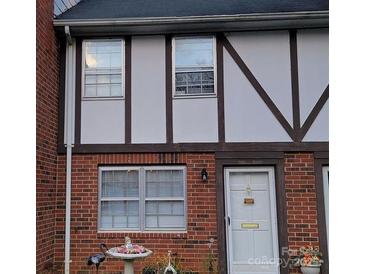 Charming Tudor-style home with brick facade, decorative trim, and a well-maintained front yard at 1300 Larchmont Pl, Salisbury, NC 28144