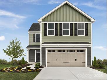 Charming two-story home features a two-car garage, landscaped yard and inviting front door at 1307 Elm Forest Ln, China Grove, NC 28023