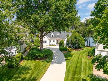 Stunning lakefront home with a beautifully landscaped front yard and circular driveway, offering curb appeal and convenient parking at 17719 Springwinds Dr, Cornelius, NC 28031