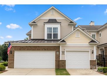 Charming townhome featuring a two-car garage and a classic facade with brick and siding accents at 44409 Oriole Dr # 200, Indian Land, SC 29707