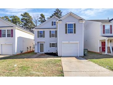 Charming two-story home featuring light siding, green shutters, a one car garage, and a well-manicured front lawn at 7214 Fox Point Dr, Charlotte, NC 28269