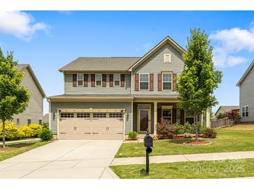 Charming two-story home featuring a manicured lawn, two car garage, and delightful curb appeal at 7263 Waterwheel Sw St, Concord, NC 28025