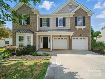Charming two-story home with brick and siding, a two-car garage, and a well-maintained front yard at 8304 Prescott Glen Pkwy, Waxhaw, NC 28173