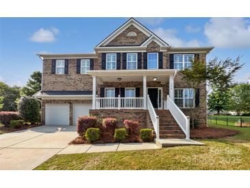 Charming brick two-story home featuring a welcoming front porch and well-manicured landscaping at 1090 Mclaren Dr, Belmont, NC 28012