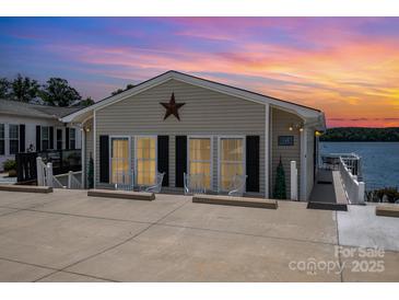 Charming lakeside cottage featuring a star decoration, inviting curb appeal, and serene waterfront views at 141 Badin Lake Cir, New London, NC 28127