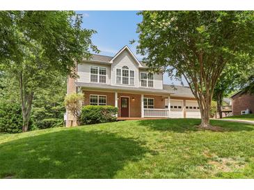 Charming two-story home with a brick and siding exterior, a manicured lawn, and a covered front porch at 176 Sharon Valley Dr, Hickory, NC 28601