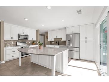 Bright kitchen with white cabinets, stainless steel appliances, and a large island with a quartz countertop at 22 Honeysuckle Ln, Clover, SC 29710