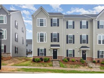 Charming two-story townhome with gray siding, black shutters, and well-maintained landscaping at 2203 Autumn Olive Ln, Stallings, NC 28104