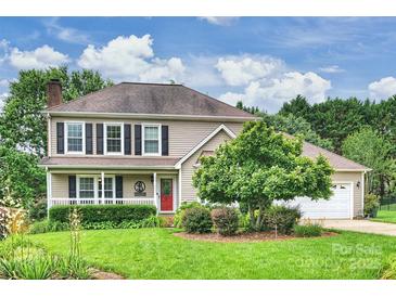 Charming two-story home with a well-manicured lawn, mature landscaping, and a welcoming front porch at 2525 Saddlehorse Ln, Gastonia, NC 28056