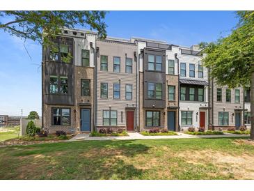 Charming townhome exteriors with brick and siding accents, complemented by lush landscaping and blue sky at 5006 Tiny Ln, Charlotte, NC 28203
