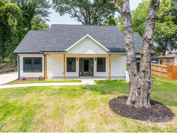 Charming home with a welcoming front porch, fresh green lawn, and lovely curb appeal at 520 E Main St, Dallas, NC 28034
