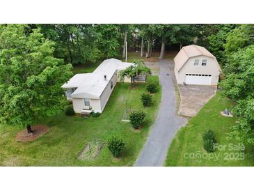 Aerial view of home with a detached garage, mature trees, and a long driveway at 8112 Blackwood Rd, Denver, NC 28037