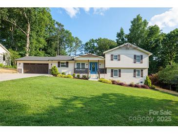 Charming home with a well-manicured lawn, attached garage, and inviting blue front door at 932 Shady Bluff Dr, Charlotte, NC 28211