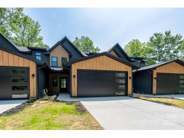 Modern townhome with a black and wood exterior, black garage doors, and concrete driveway at 1524 Enochville Rd, Kannapolis, NC 28081