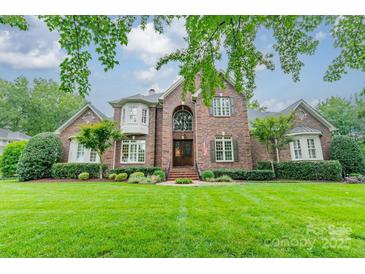 Brick two-story home featuring a manicured lawn and a symmetrical design, complete with mature landscaping at 2300 Richardson Dr, Charlotte, NC 28211