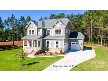 Charming two-story home with manicured lawn and a welcoming covered porch at 277 Triple Ponds Ct, Clover, SC 29710