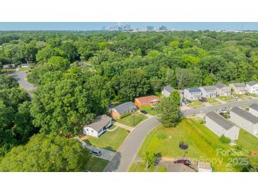 Overhead view of a neighborhood with mature trees and glimpse of the Charlotte skyline in the distance at 3608 Crestridge Dr, Charlotte, NC 28217