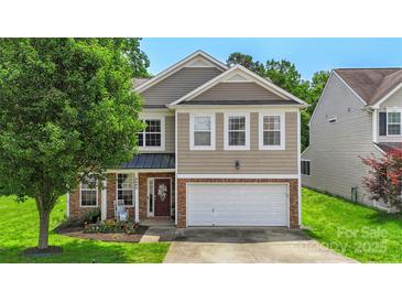 Charming two-story home featuring a brick and siding facade, well-manicured lawn and an attached two-car garage at 4006 Centerview Dr, Indian Trail, NC 28079