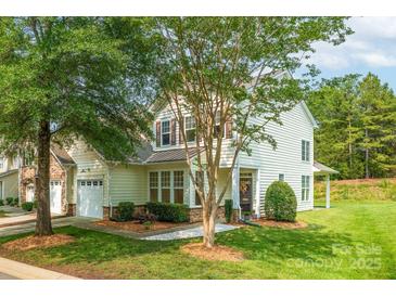 Charming home with manicured lawn, lush landscaping and neutral siding on a bright sunny day at 5963 Pale Moss Ln, Charlotte, NC 28269
