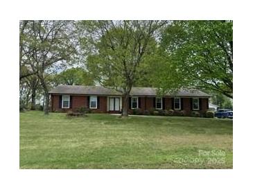 Charming single-story brick home with a well-maintained front yard and mature trees at 8616 Fallsdale Dr, Charlotte, NC 28214
