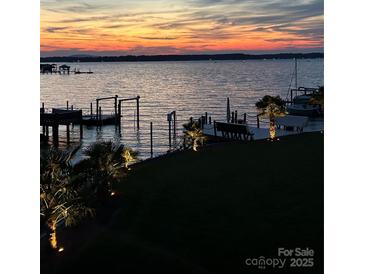 Picturesque waterfront view with docks, palm trees, and a colorful sunset reflected on the calm water at 22501 John Gamble Rd, Cornelius, NC 28031
