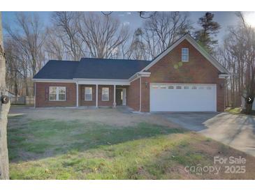 Charming brick home with a well-manicured lawn and attached two-car garage at 2712 Thornburg Ct, Monroe, NC 28110