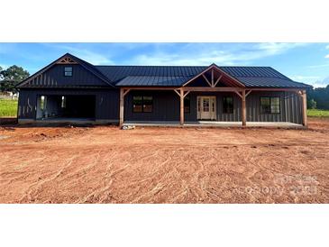 New construction featuring a dark exterior, metal roof, exposed timber accents, and attached garage at 3000 Paul Payne Store Rd, Taylorsville, NC 28681