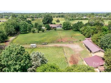 Expansive aerial view of property featuring a residence and lush surrounding landscape with mature trees at 4026 Biggerstaff Rd, Maiden, NC 28650