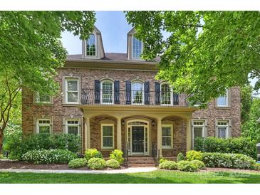 Elegant brick home featuring a charming balcony, manicured lawn, and tasteful landscaping at 7319 Stonehaven Dr, Waxhaw, NC 28173