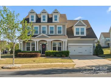 Charming two-story home featuring a welcoming front porch, manicured lawn, and attached two car garage at 1001 Hampton Grove Rd, Waxhaw, NC 28173