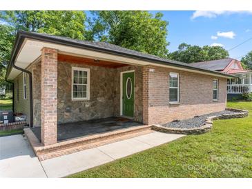 Charming single-story home featuring brick and stone accents, a covered porch, and a well-manicured lawn at 1116 S Juniper St, Kannapolis, NC 28081
