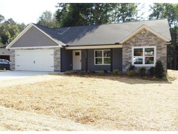 Charming single-story home featuring a gray exterior, stone accents, and a two-car garage in a suburban setting at 1802 Cooper Ave, Kannapolis, NC 28081