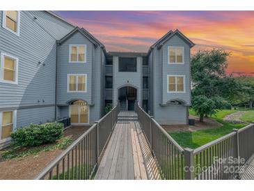 Inviting condo exterior with dusk sky, bridge entrance, and well-maintained landscaping at 18741 Nautical Dr # 205, Cornelius, NC 28031