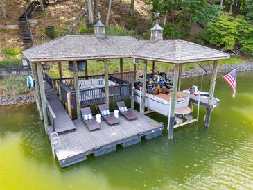 A covered boat dock on the water with lounge seating and a boat lift; features an American flag at 2004 Marquesas Ave, Tega Cay, SC 29708