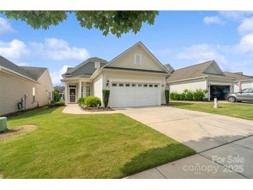 Charming home featuring a well-manicured lawn, neat landscaping, and an attached two-car garage at 23117 Whimbrel Cir, Fort Mill, SC 29707