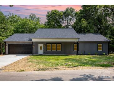 Charming one-story home featuring a gray exterior, black garage door, and well-manicured lawn at 627 West Main Ext, Lincolnton, NC 28092