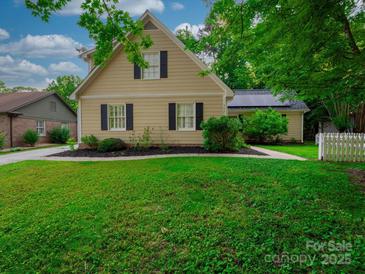 Charming home with a well-manicured lawn, mature trees, and black shutters at 7521 Surreywood Pl, Charlotte, NC 28270