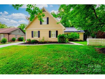 Charming two-story home with yellow siding, black shutters, and a well-manicured green lawn at 7521 Surreywood Pl, Charlotte, NC 28270