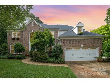 Charming brick home with a two-car garage, manicured lawn, and tasteful landscaping at 8219 Beardsley Dr, Charlotte, NC 28269