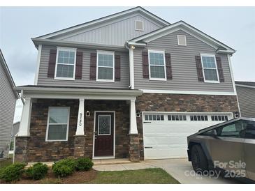 Charming two-story home featuring stone accents, a two-car garage, and a welcoming front porch at 9730 Tea Garden Dr, Gastonia, NC 28056
