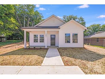 Charming white home with a welcoming front porch and well-manicured lawn under a bright blue sky at 1407 7Th St # 4, Statesville, NC 28677