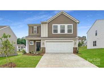Charming two-story home boasts a two-car garage, manicured lawn, and welcoming front entrance at 146 Astor St, Troutman, NC 28166