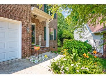 Charming brick home featuring a welcoming front porch with beautiful landscaping and a 'Welcome' sign at 167 Foxtail Dr, Mooresville, NC 28117