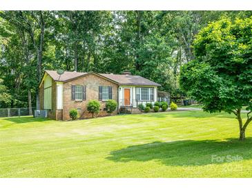 A cozy brick home with a tidy front yard and mature landscaping, creating a welcoming curb appeal at 214 Cottage Pl, York, SC 29745