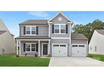 Charming two-story home featuring a two-car garage, gray siding, black shutters, and a welcoming front porch at 219 Redondo Dr # 65, Wingate, NC 28174