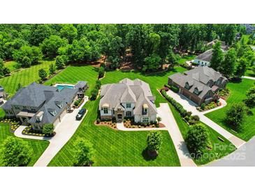 Expansive estate featuring pristine landscaping, a pool, and a grand home with a long driveway and ample parking at 300 Wheatberry Hill Dr, Weddington, NC 28104