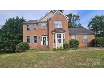 Traditional brick home with a well-manicured lawn, neutral shutters and a bay window adds curb appeal at 4227 Kiser Woods Sw Dr, Concord, NC 28025