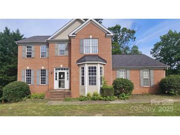 Charming two-story brick home with a bay window, gray shutters, and a well-maintained front yard at 4227 Kiser Woods Sw Dr, Concord, NC 28025