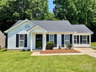 Charming single-story home with white siding, black shutters, and a well-manicured lawn at 5800 Silver Eagle Dr, Charlotte, NC 28214